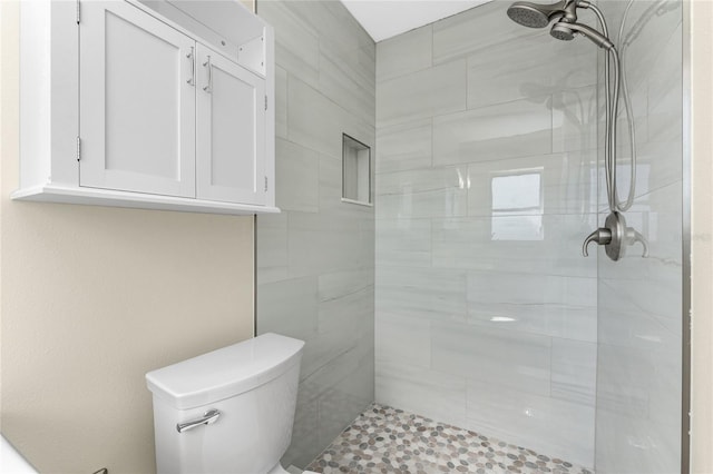 bathroom with tiled shower and toilet