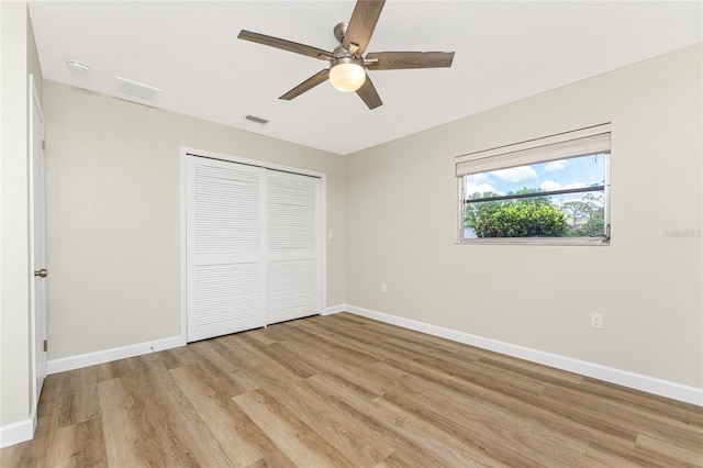 unfurnished bedroom featuring a closet, light hardwood / wood-style flooring, and ceiling fan