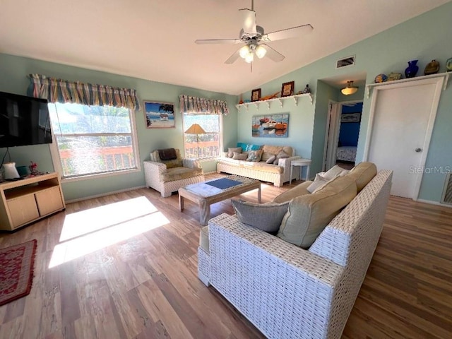 living room with wood-type flooring, vaulted ceiling, and ceiling fan