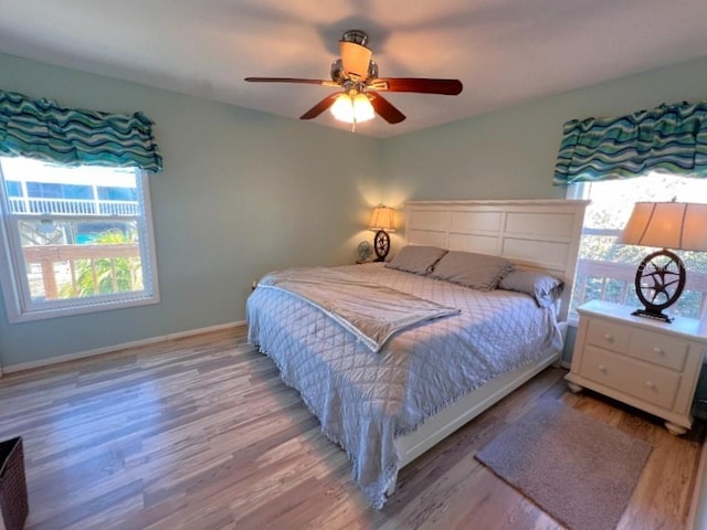 bedroom with ceiling fan, baseboards, and wood finished floors