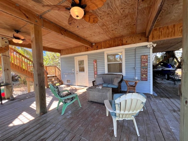 wooden terrace with ceiling fan and an outdoor hangout area