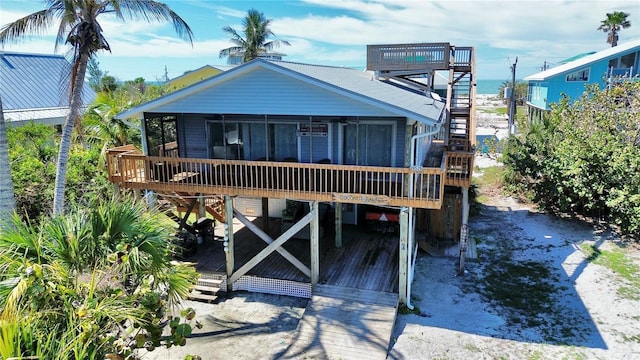 view of front facade with a sunroom, stairway, and a deck