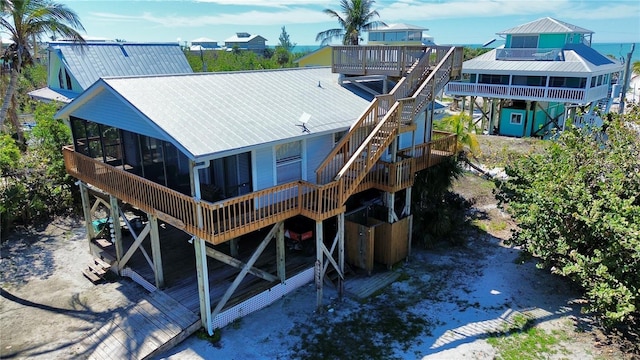 rear view of house featuring a sunroom and metal roof