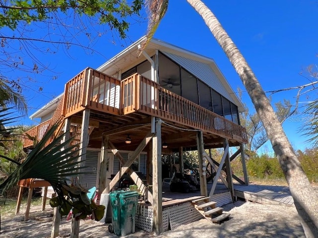 back of property with a deck, ceiling fan, and stairway