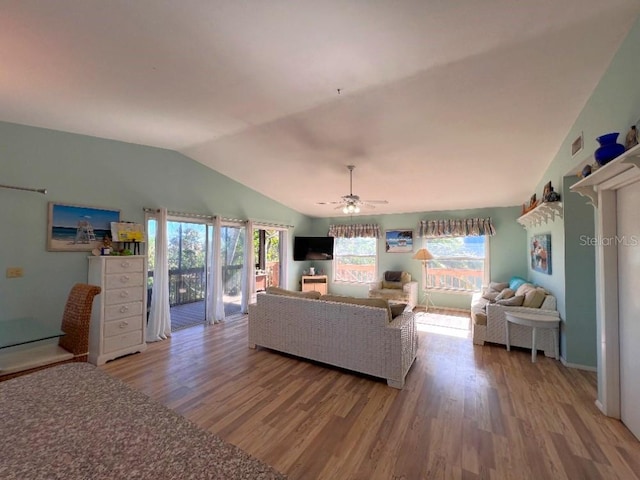 unfurnished living room with ceiling fan, visible vents, vaulted ceiling, and wood finished floors