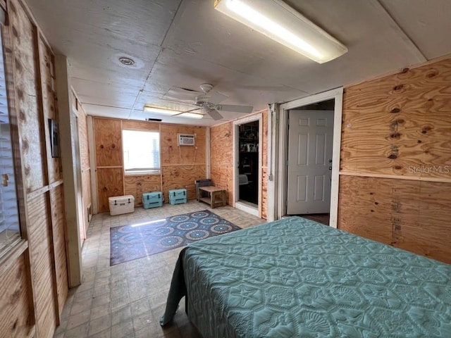 bedroom featuring light floors, wood walls, and a ceiling fan