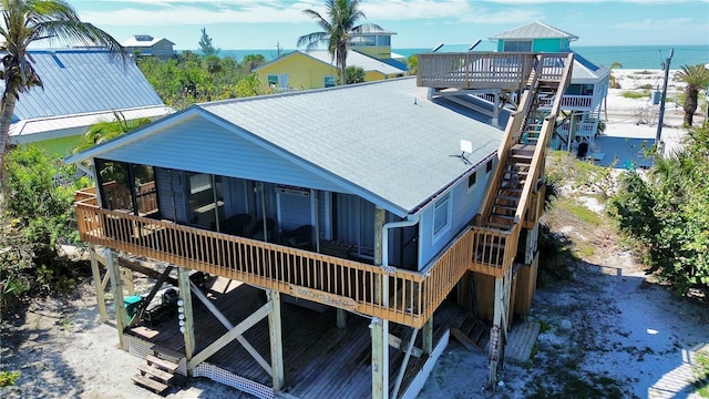 rear view of house featuring a deck, metal roof, and stairway