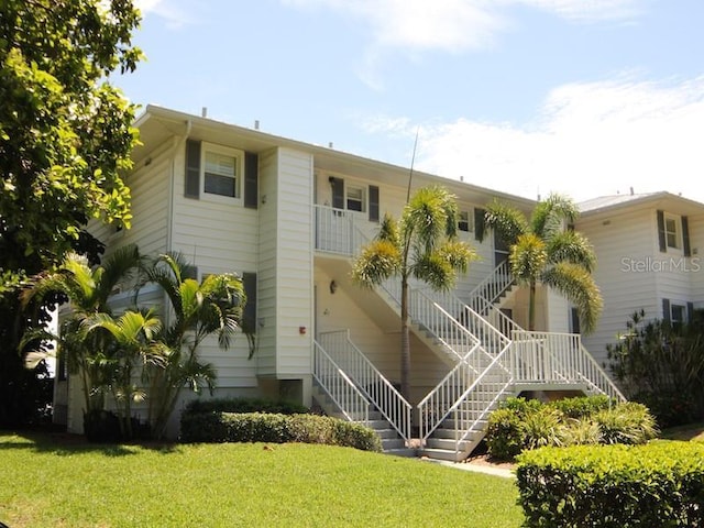 rear view of property featuring a lawn