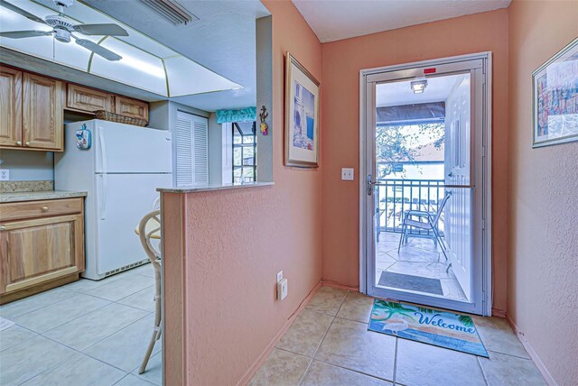 524 Pine Hollow Cir Unit 524, Englewood, FL 34223 - doorway with plenty of natural light, ceiling fan, a textured wall, and light tile patterned floors
