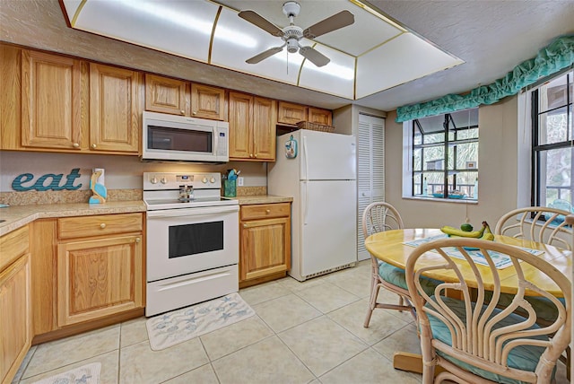524 Pine Hollow Cir Unit 524, Englewood, FL 34223 - kitchen featuring white appliances, light countertops, light tile patterned flooring, and a ceiling fan