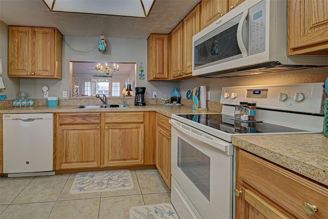 524 Pine Hollow Cir Unit 524, Englewood, FL 34223 - kitchen featuring white appliances, a chandelier, light countertops, light tile patterned floors, and brown cabinetry