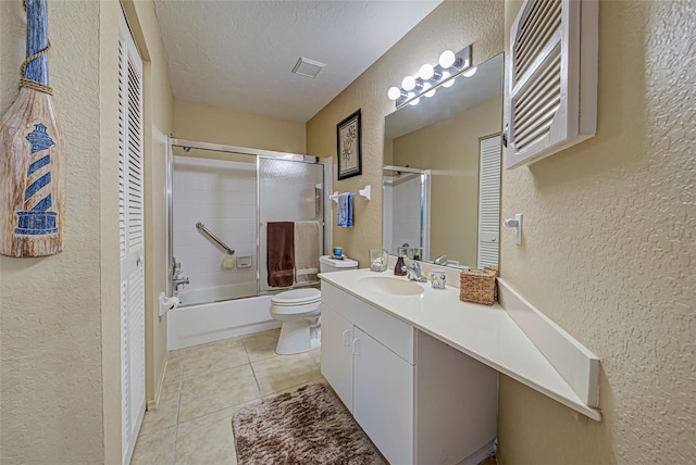 524 Pine Hollow Cir Unit 524, Englewood, FL 34223 - full bath with a textured wall, vanity, a textured ceiling, tile patterned flooring, and bath / shower combo with glass door