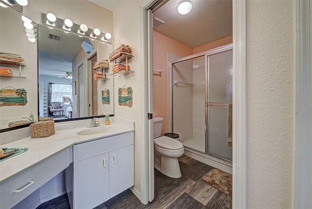 524 Pine Hollow Cir Unit 524, Englewood, FL 34223 - ensuite bathroom featuring vanity, a shower stall, wood finished floors, ceiling fan, and a textured wall