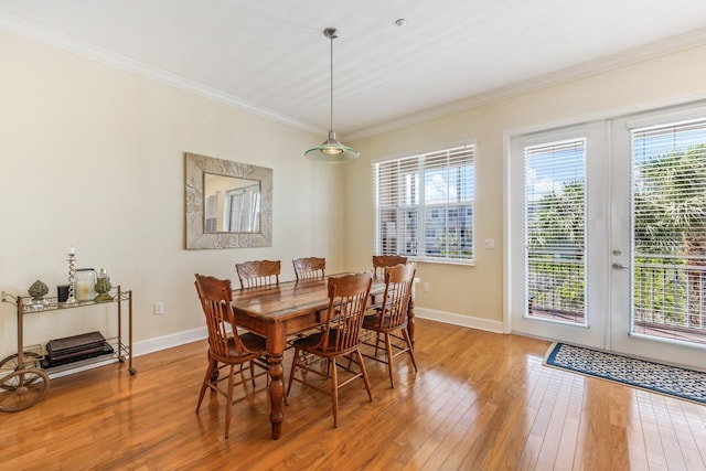 dining room with french doors, light hardwood / wood-style floors, and crown molding