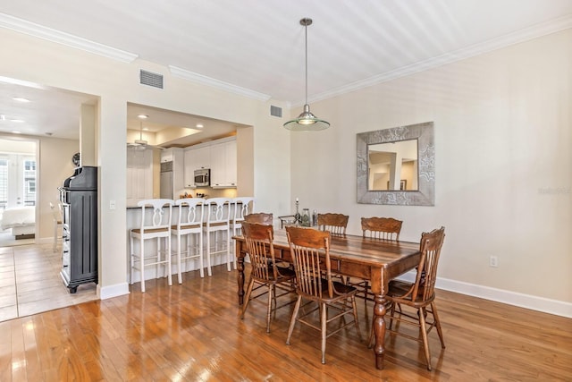 dining area featuring hardwood / wood-style floors and ornamental molding