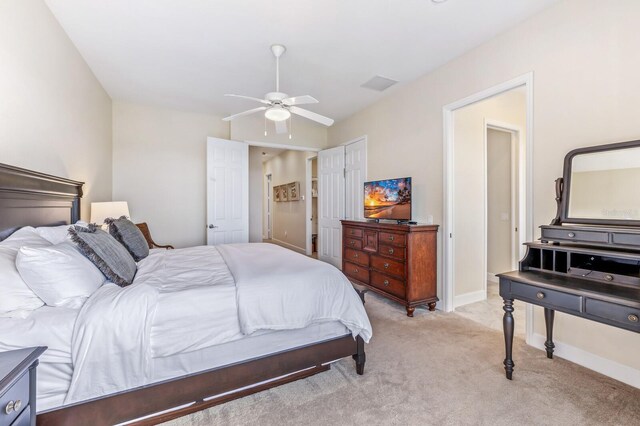 bedroom with a closet, light colored carpet, and ceiling fan