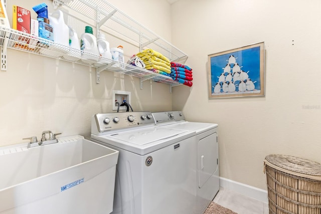 laundry room featuring separate washer and dryer, sink, and light tile patterned floors