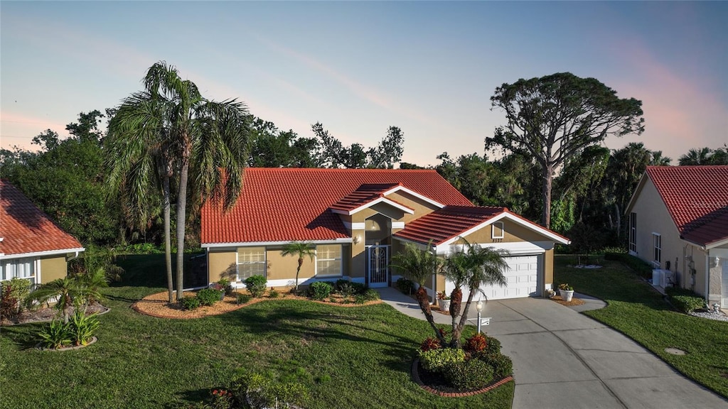 view of front of home featuring a yard, central AC, and a garage