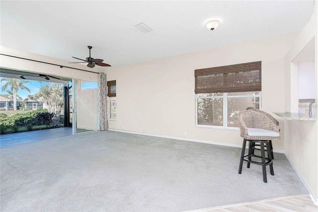 interior space featuring light carpet and ceiling fan