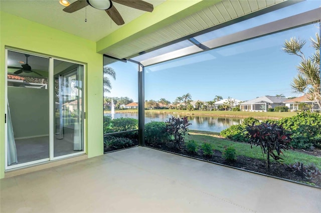 unfurnished sunroom with a water view and ceiling fan