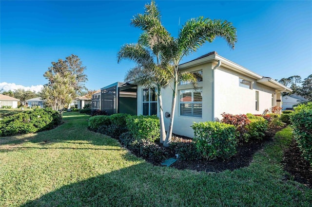 view of property exterior with a yard and a lanai