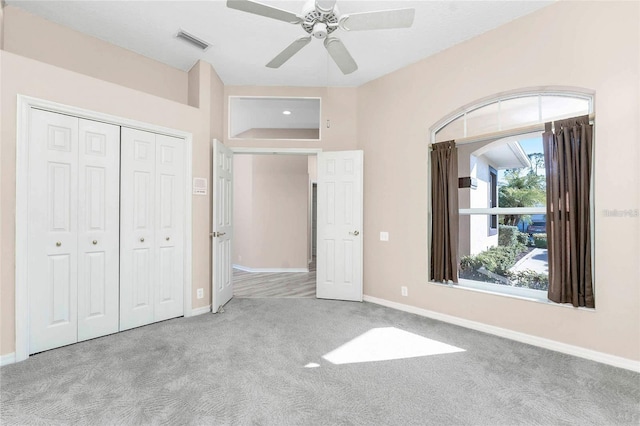 unfurnished bedroom featuring ceiling fan, light carpet, and a closet