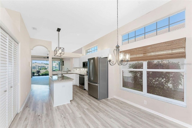 kitchen featuring white cabinetry, a kitchen island, appliances with stainless steel finishes, a chandelier, and pendant lighting