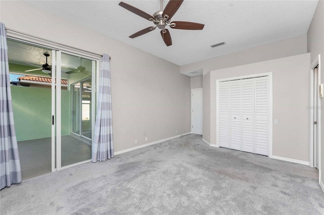 unfurnished bedroom featuring ceiling fan, light carpet, and a textured ceiling