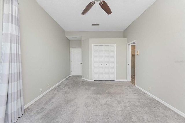 unfurnished bedroom with light carpet, ceiling fan, and a closet