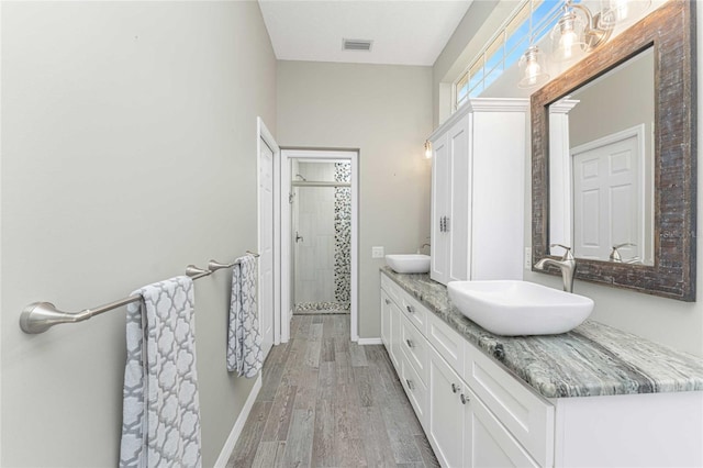 bathroom with vanity, walk in shower, and hardwood / wood-style floors