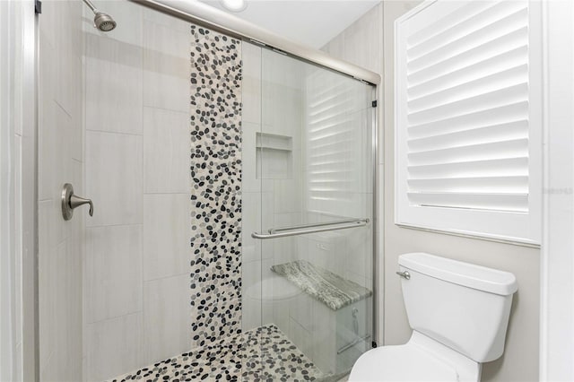 bathroom featuring an enclosed shower and toilet