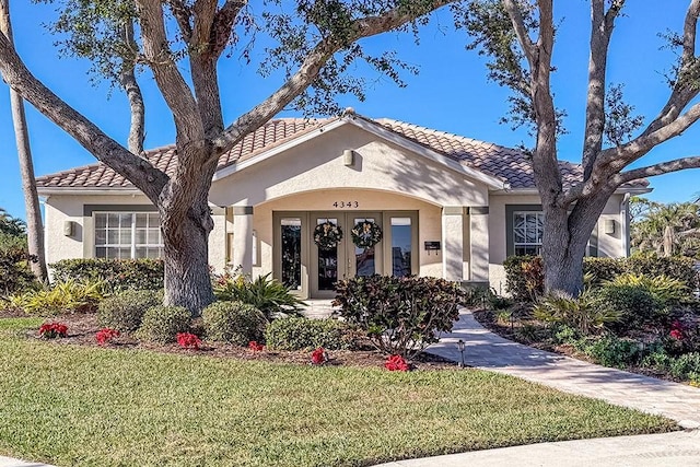 view of front facade with french doors and a front lawn