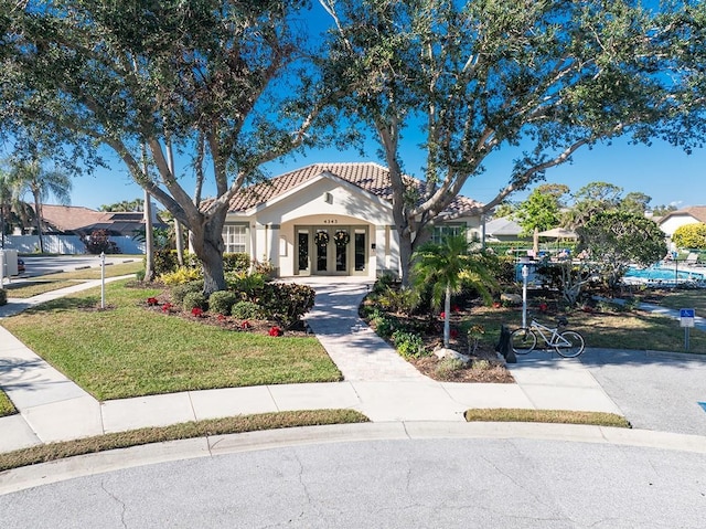 mediterranean / spanish-style home featuring french doors and a front lawn