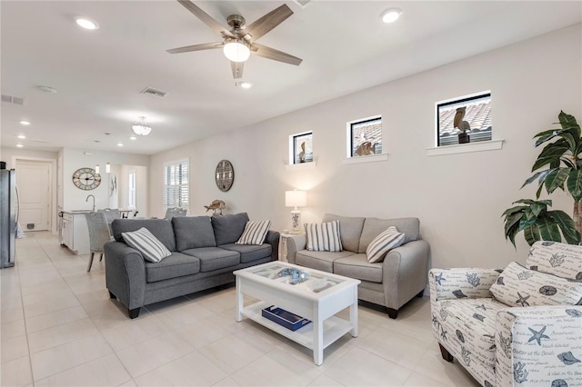 living room featuring ceiling fan, light tile patterned floors, and sink