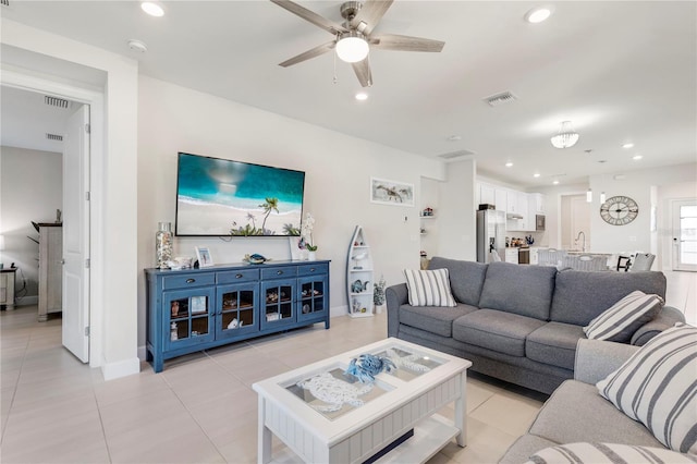 tiled living room featuring ceiling fan and sink