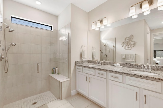 bathroom featuring tile patterned flooring, vanity, and a shower with door