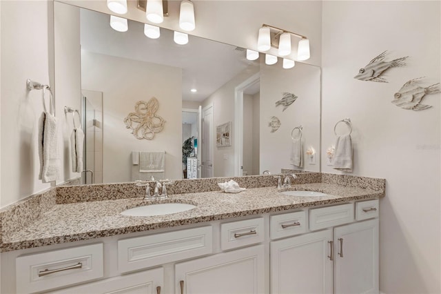 bathroom with a shower with door and vanity