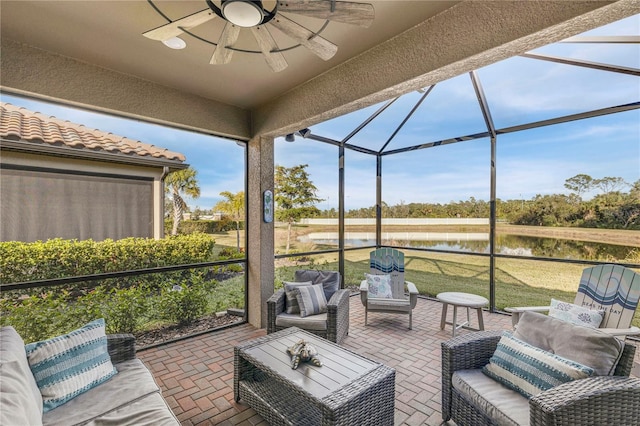 sunroom featuring ceiling fan and a water view