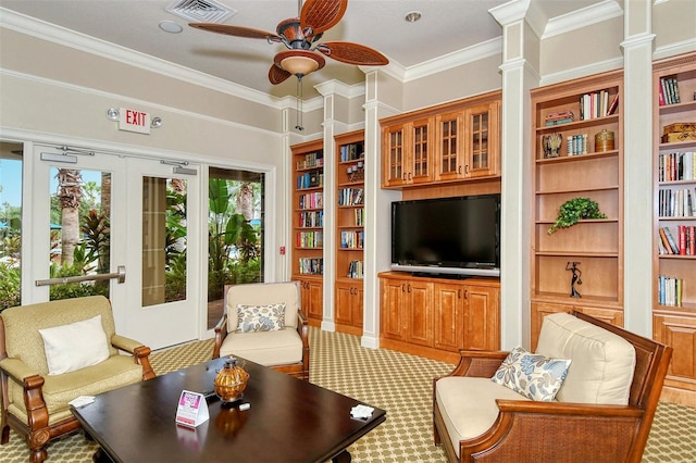 living room featuring built in shelves, ceiling fan, and ornamental molding