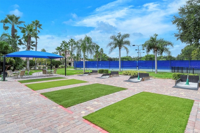 view of property's community with a patio and a lawn