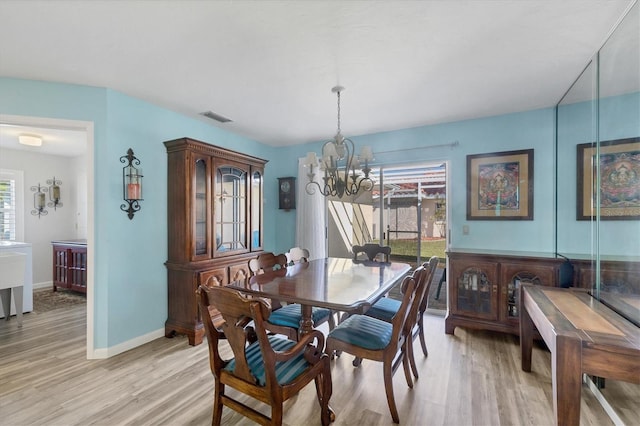 dining room with a chandelier and light wood-type flooring