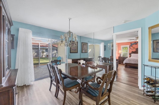 dining area featuring light hardwood / wood-style floors and ceiling fan with notable chandelier