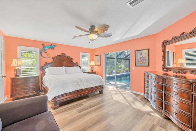 bedroom featuring ceiling fan, a textured ceiling, access to outside, and light hardwood / wood-style flooring