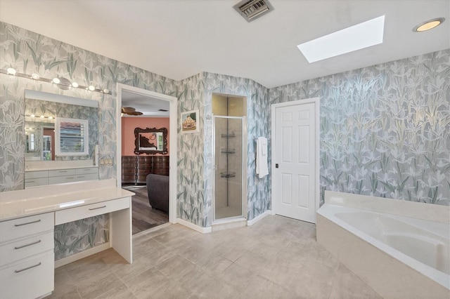 bathroom featuring vanity, plus walk in shower, and a skylight