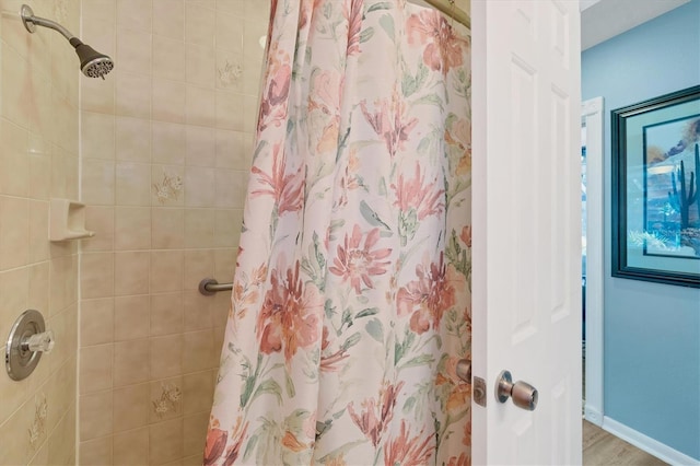 bathroom with a shower with shower curtain and hardwood / wood-style flooring