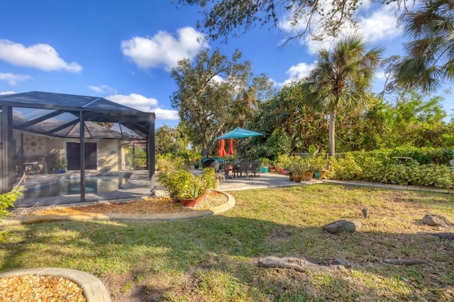 view of yard featuring glass enclosure and a patio area