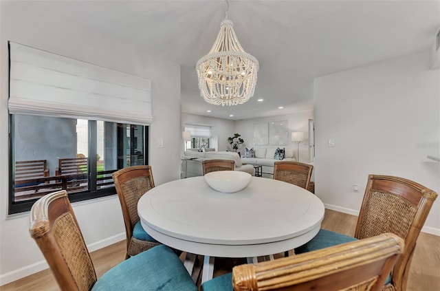 dining space featuring a notable chandelier and light wood-type flooring