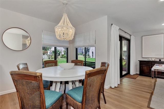 dining room featuring a notable chandelier and light hardwood / wood-style flooring