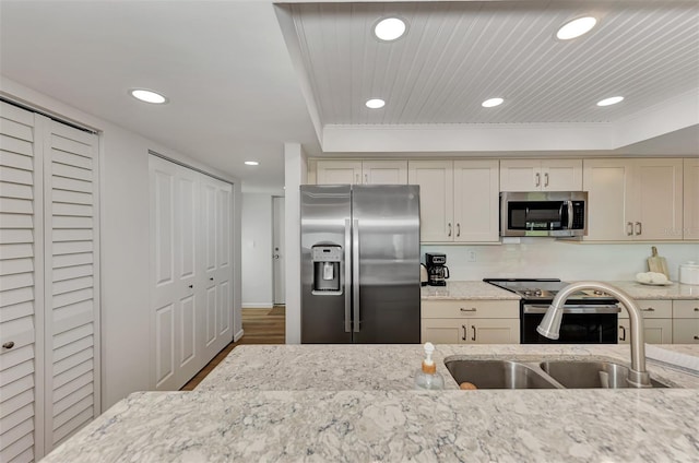 kitchen with sink, dark wood-type flooring, cream cabinetry, and appliances with stainless steel finishes