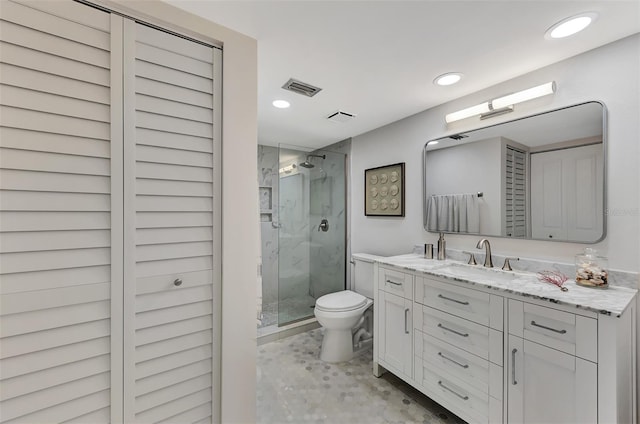 bathroom with toilet, vanity, and walk in shower